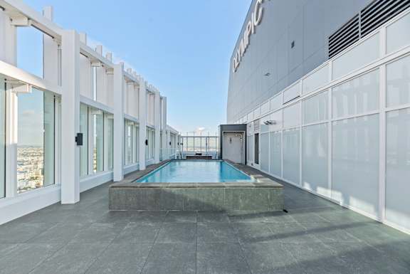 A modern building with a pool in the middle of the room. at Olympic + Hill Apartments, Apartments, Los Angeles, CA