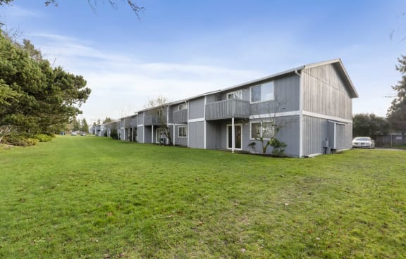 a row of apartment buildings on a green field