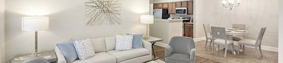 Living room with a dining room table and a kitchen at Highlands Apartment Homes, Bartlett, TN