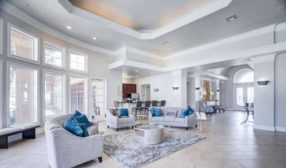 A spacious living room with a grey sofa and a white coffee table.