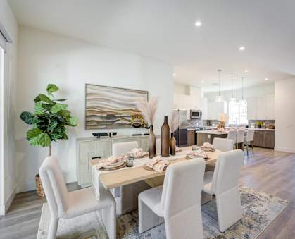 a living room and dining room with a table and chairs