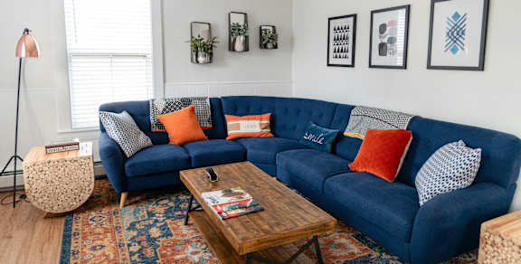 A living room with a blue couch and a wooden coffee table.