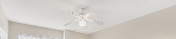 Comfortable Bedroom with a bed and a ceiling fan at Highlands Apartment Homes, Tennessee , 38135