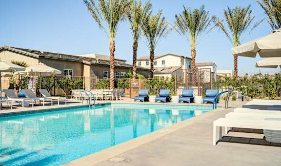a swimming pool with chairs and umbrellas at the resort