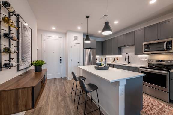 A modern kitchen with a white island and stainless steel appliances.