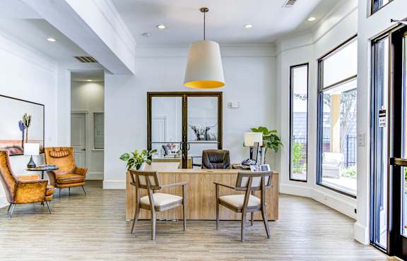 A modern dining room with a wooden table and chairs.