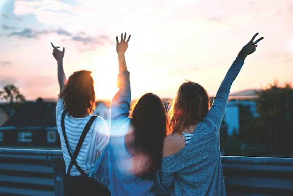 a group of women with their hands in the air