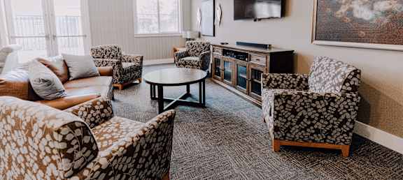 a living room with couches and chairs and a television