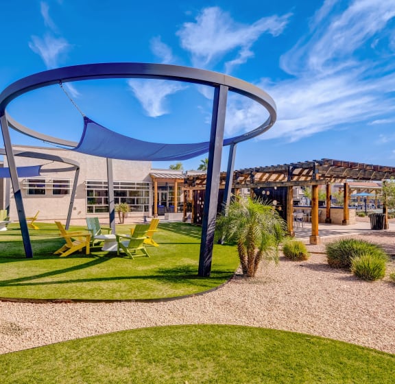 a playground with chairs and a canopy in front of a building