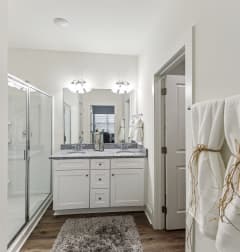 a bathroom with a shower and a sink and a mirror