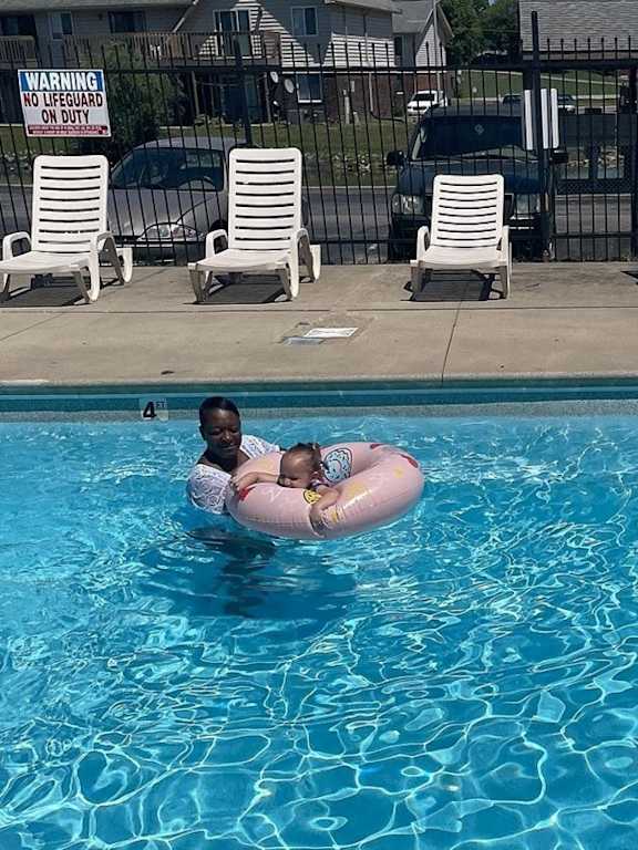 a young boy in a pool with a life jacket