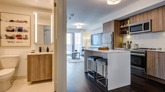 A modern kitchen with a white countertop and wooden cabinets.