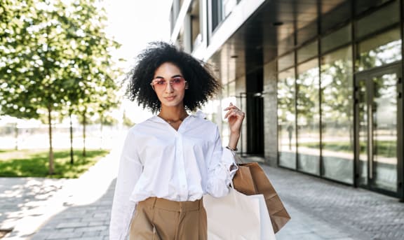 a woman walking down the street holding shopping bags