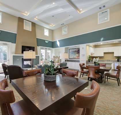 a resident clubhouse with a fireplace and dining table