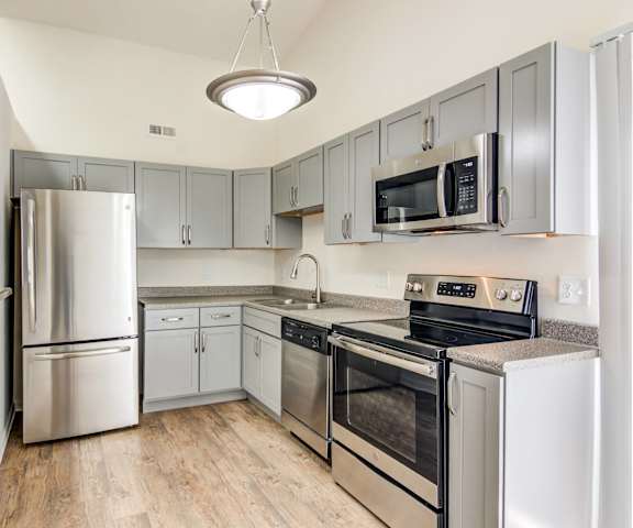 a kitchen with stainless steel appliances and white cabinets