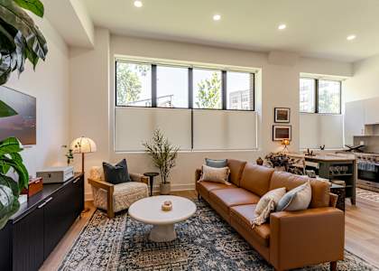 A living room with a brown couch and a white coffee table.