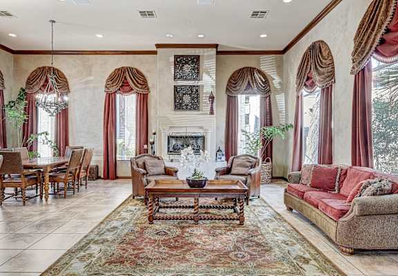 A living room with a fireplace and a rug.
