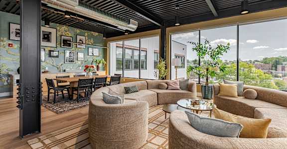 A modern living room with a large window and a dining table.