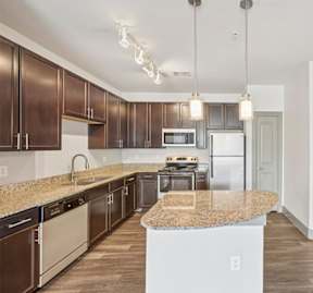 A kitchen with brown cabinets and a granite countertop.