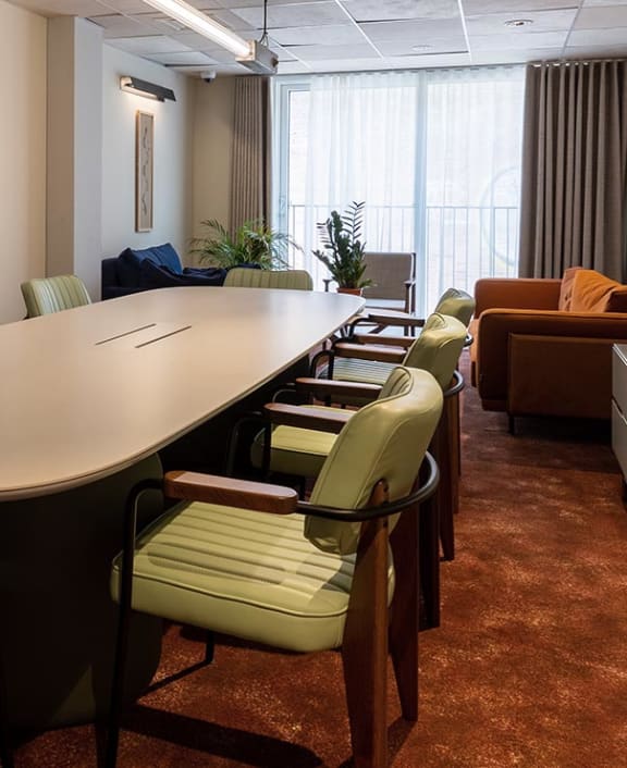 an empty meeting room with chairs and a long table