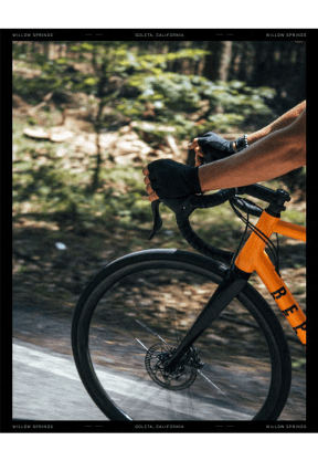 a person holding a glove on the handlebars of a bike