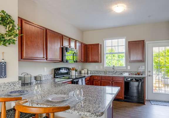a kitchen with granite counter tops and wooden cabinets