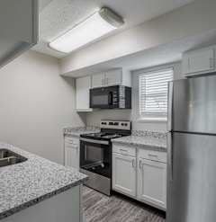 a kitchen with granite counter tops and stainless steel appliances