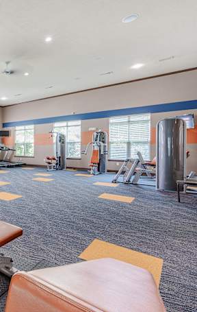 A gym with treadmills, elliptical machines, and a stationary bike.at Creekview, Midvale, UT