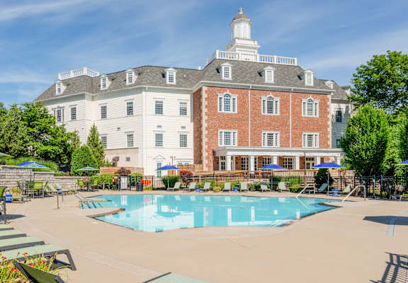 a resort style swimming pool with a building in the background