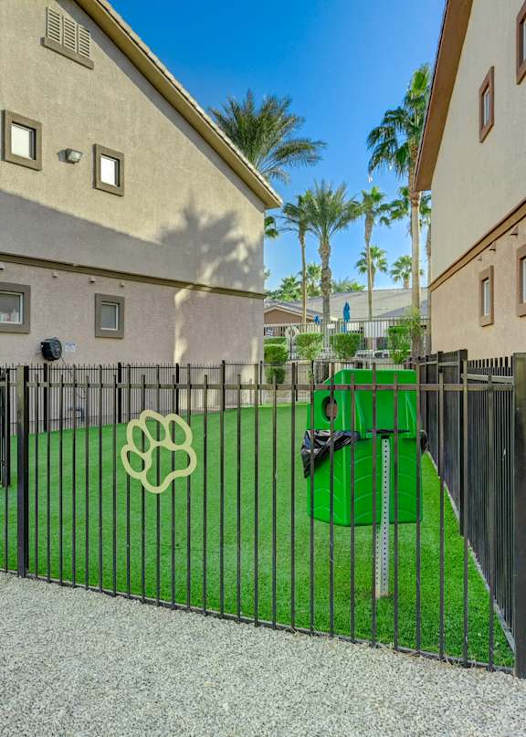 A black gate with a white symbol on it is in front of a building.