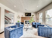 Thumbnail 5 of 28 - A living room with blue couches and a fireplace.