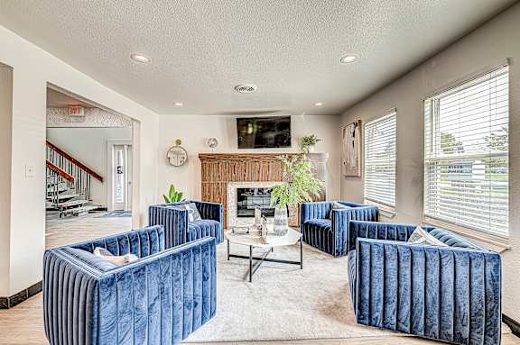 A living room with blue couches and a fireplace.