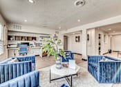 Thumbnail 1 of 28 - A living room with blue velvet chairs and a white coffee table.
