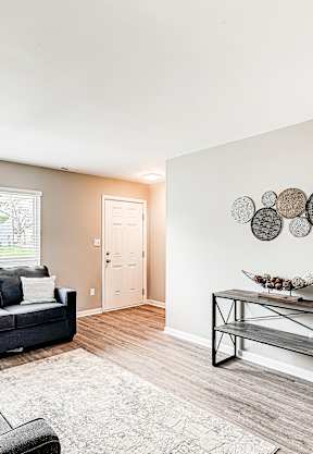 A living room with a grey couch and a black metal coffee table.