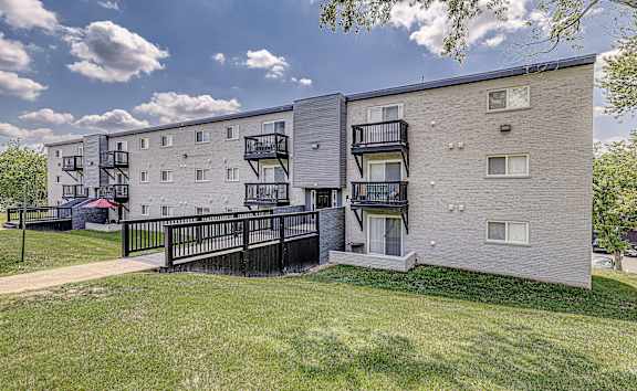 Apartment buildings with balconies and a black fence in front.