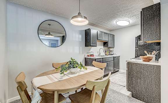 A kitchen with a round table and chairs.
