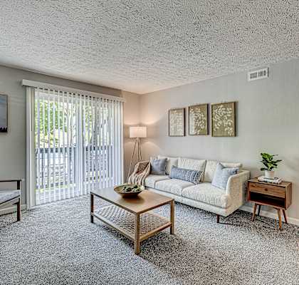 A living room with a couch, chair, and table.