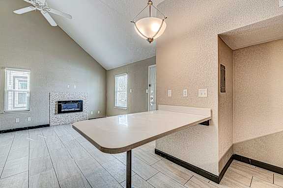 A room with a fireplace and a table in the foreground.