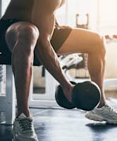 A man is working out with dumbbells in a gym.
