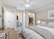 Thumbnail 2 of 9 - A bedroom with a large bed and a ceiling fan.
