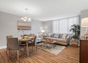 Thumbnail 2 of 3 - A modern living room with a dining table and a couch.