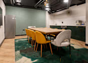 Thumbnail 6 of 8 - A dining room with a table and chairs.