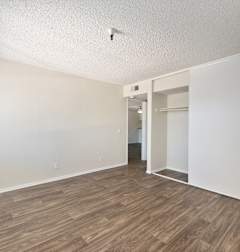 A room with wooden flooring and white walls.