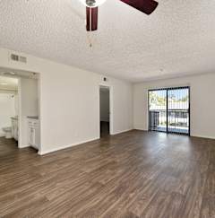 A room with wooden floors and a ceiling fan.