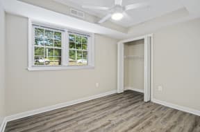 a bedroom with hardwood floors and a ceiling fan