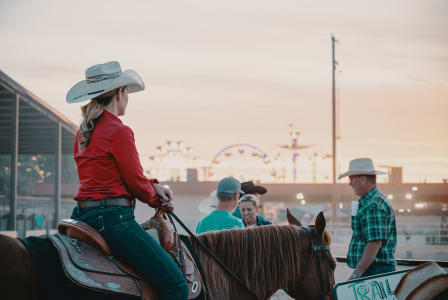 a woman riding on the back of a brown horse