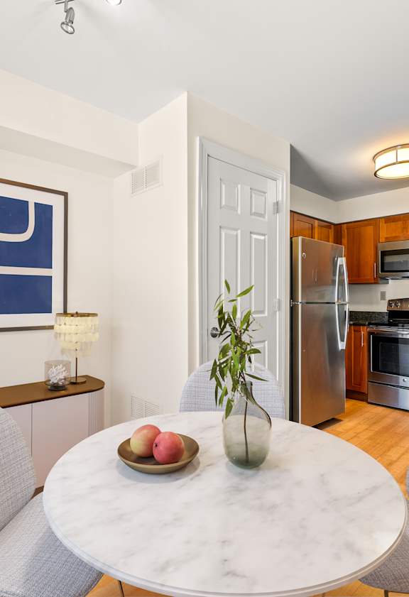 A modern kitchen with a dining table set for two.