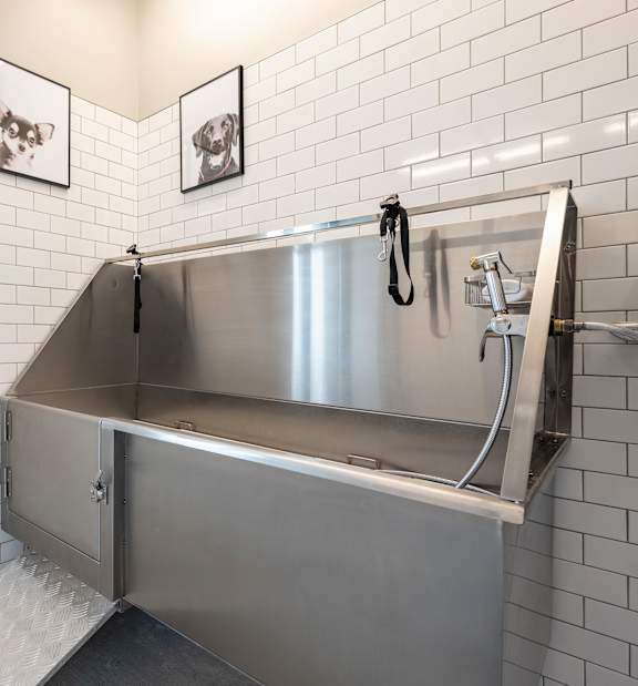 a stainless steel bathroom with a shower and a sink
