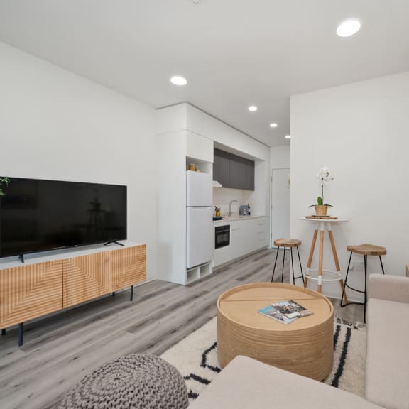 a living room with a gray couch and a white table