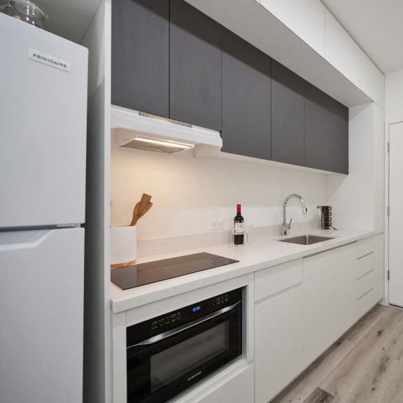 a kitchen with white cabinets and a refrigerator and a sink